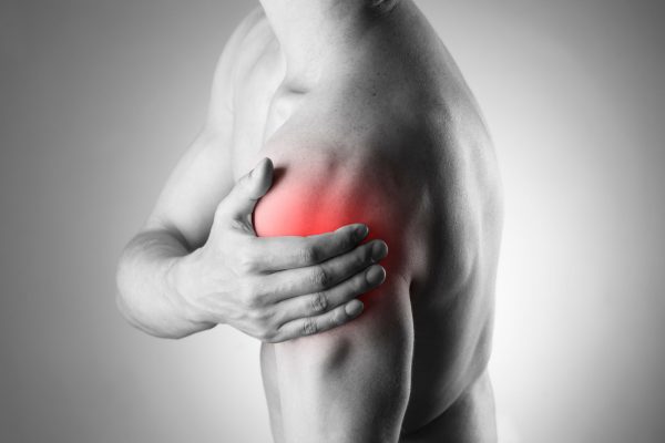 Man with pain in shoulder. Pain in the human body Man with pain in shoulder. Pain in the human body. Black and white photo with red dot